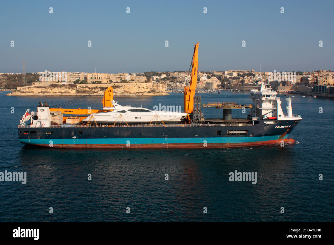 The ship Palmarola bringing a large yacht to Malta's Grand Harbour Stock Photo