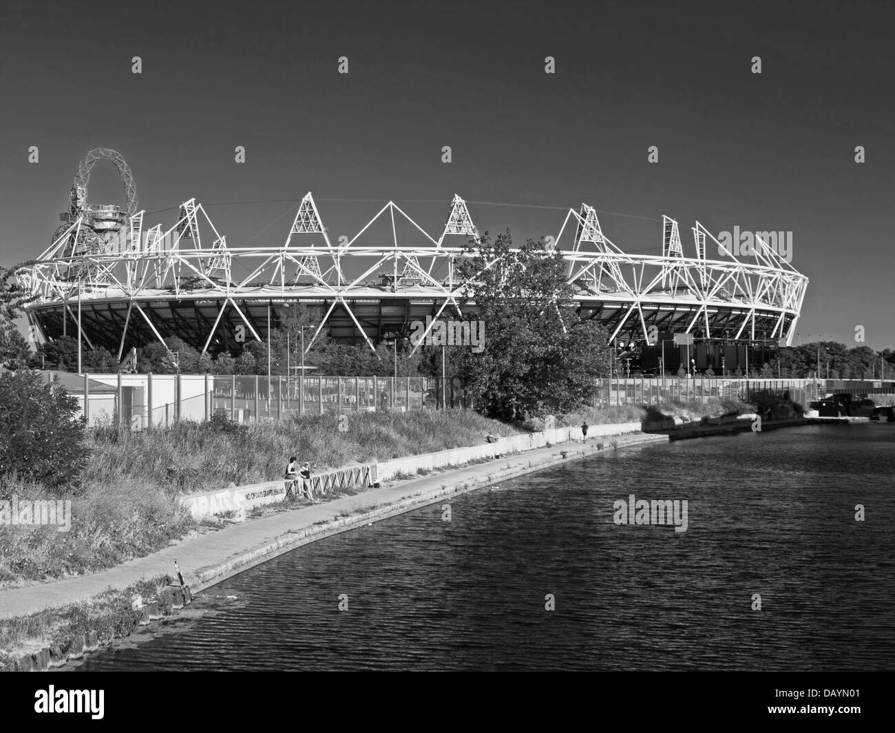 Black and white view of the Olympic Stadium and the ArcelorMittal Orbit across the River Lea (Lee) Navigation, Hackney Wick Stock Photo