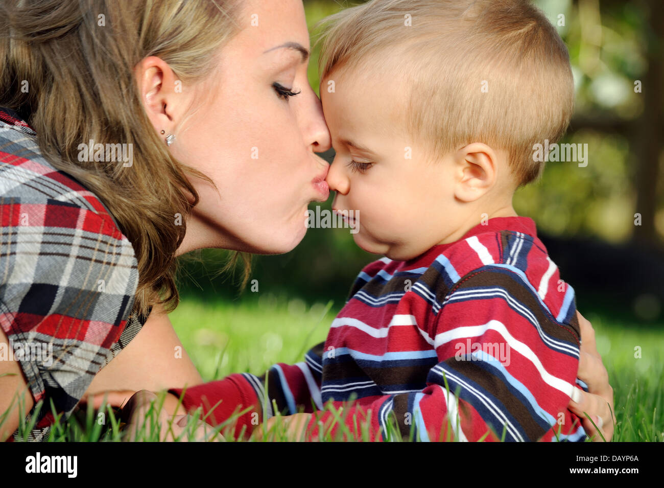 Мама учит сына целоваться. Мама целует. Мама целует малыша. Поцелуй помадой ребёнка. Ребенок целует маму в щечку.