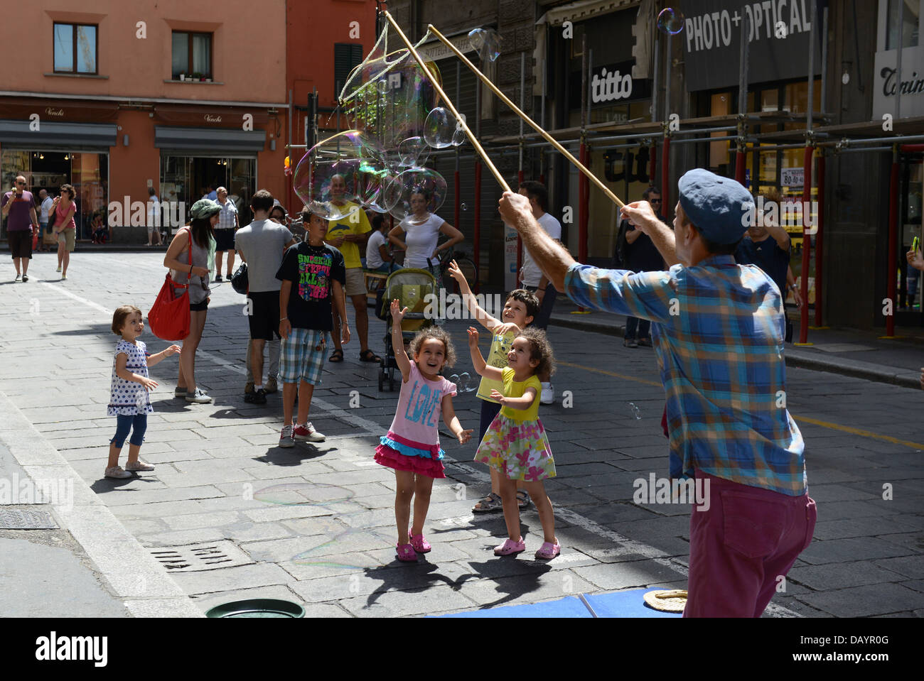 Man making bubbles entertaining children in Bologna Italy Stock Photo