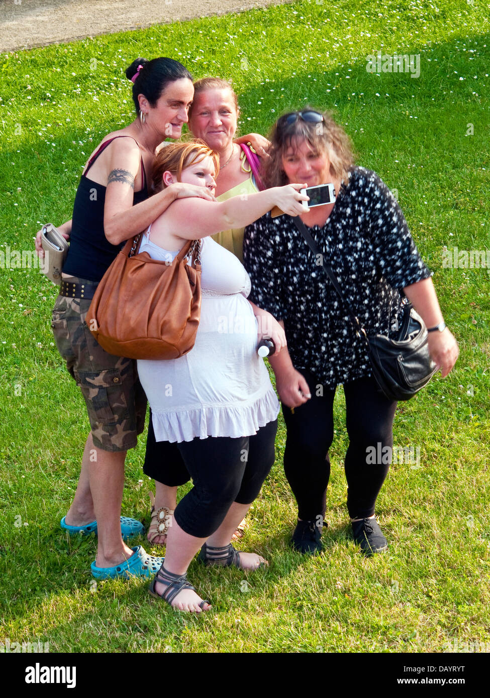 Four women taking group photo / selfie with smart-phone - France. Stock Photo
