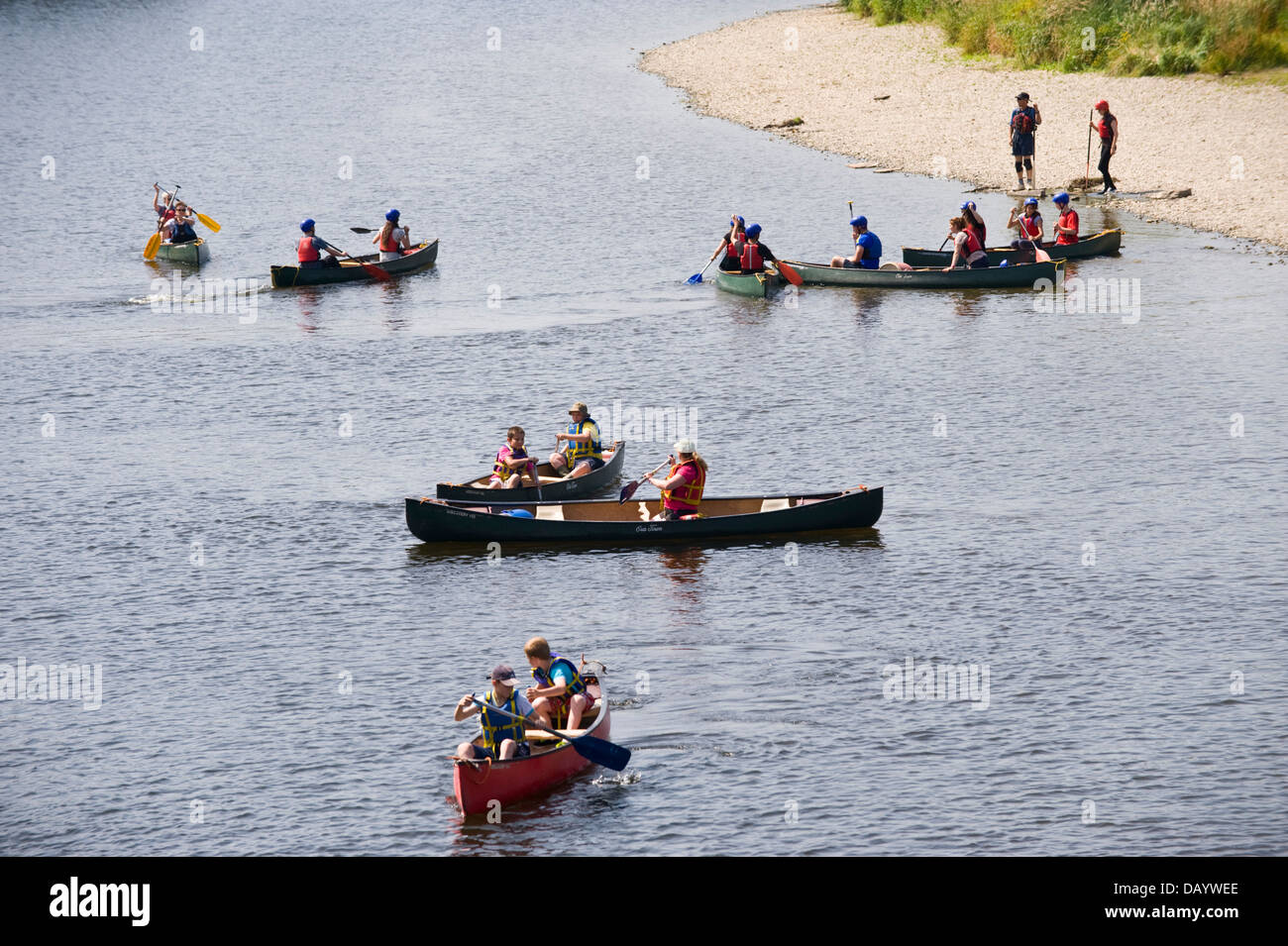 Children & adults in open canoes practice their canoe skills before