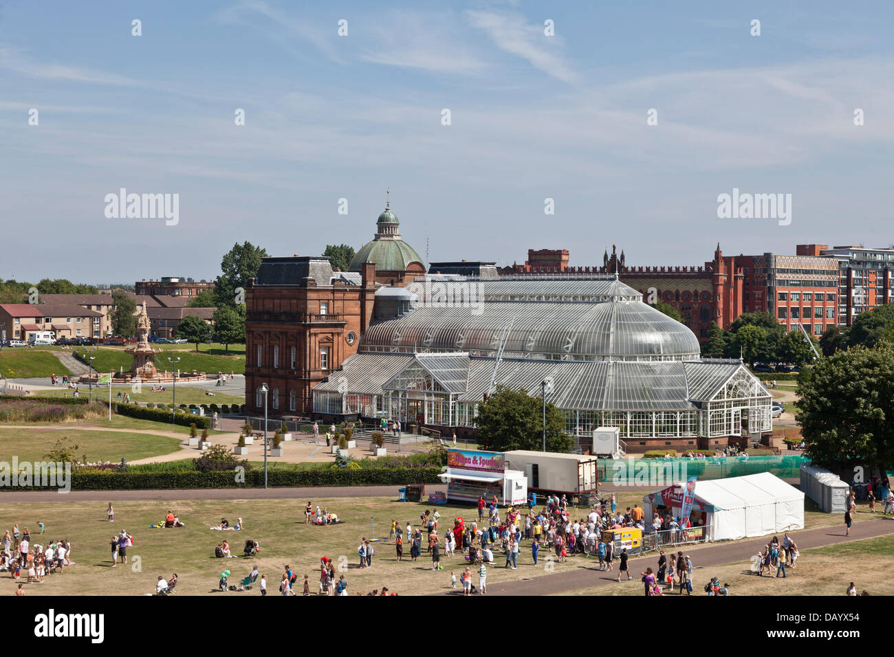 Glasgow, Scotland, 21st July, 2013. Some visitors to the Glasgow Show 2013 on Glasgow Green. In the background are the People's Palace, the Doulton Fountain and the Templeton Business Centre (formerly Templeton's carpet Factory). Stock Photo