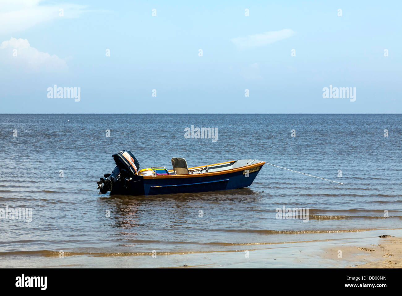 Small fishing boat skiff with outboard motor and seats anchored moored on  beach along the Gulf Coast of Florida in Cedar Key Stock Photo - Alamy