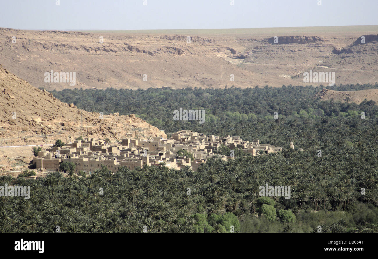 A village consisting of clay buildings lies next to extended palm tree plantations near an oasis in the 'Ziz' valley at the foothills of the Atlas mountain range in central Morocco, 31 March 2007. Photo: Marijan Murat Stock Photo