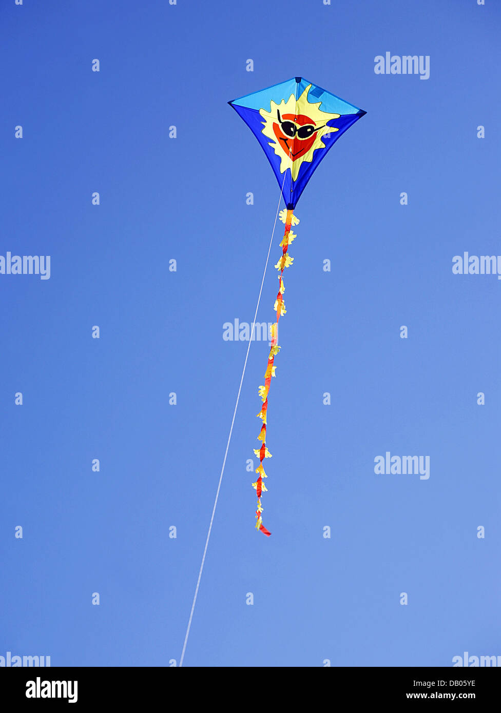 A colourful children's kite flies in the blue sky at the beach of