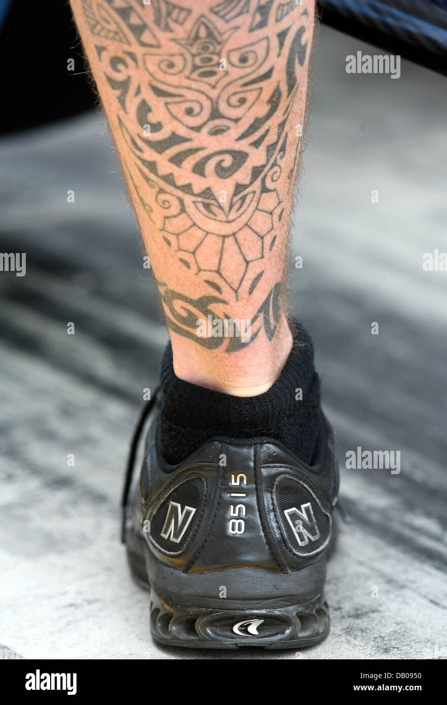 The tattoed calf of a mechanic pictured in the pit lane during Practice 2 at the Nurburgring, Germany, 20 July 2007. The 2007 Formula 1 Grand Prix of Europe that is held on 22 July. Photo: Roland Weihrauch Stock Photo