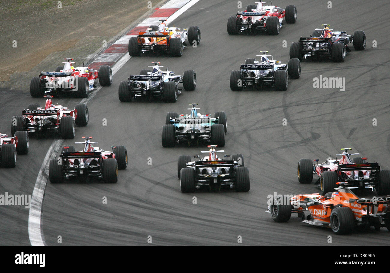 Racing cars cut the first corner after the start of the Formula One ...