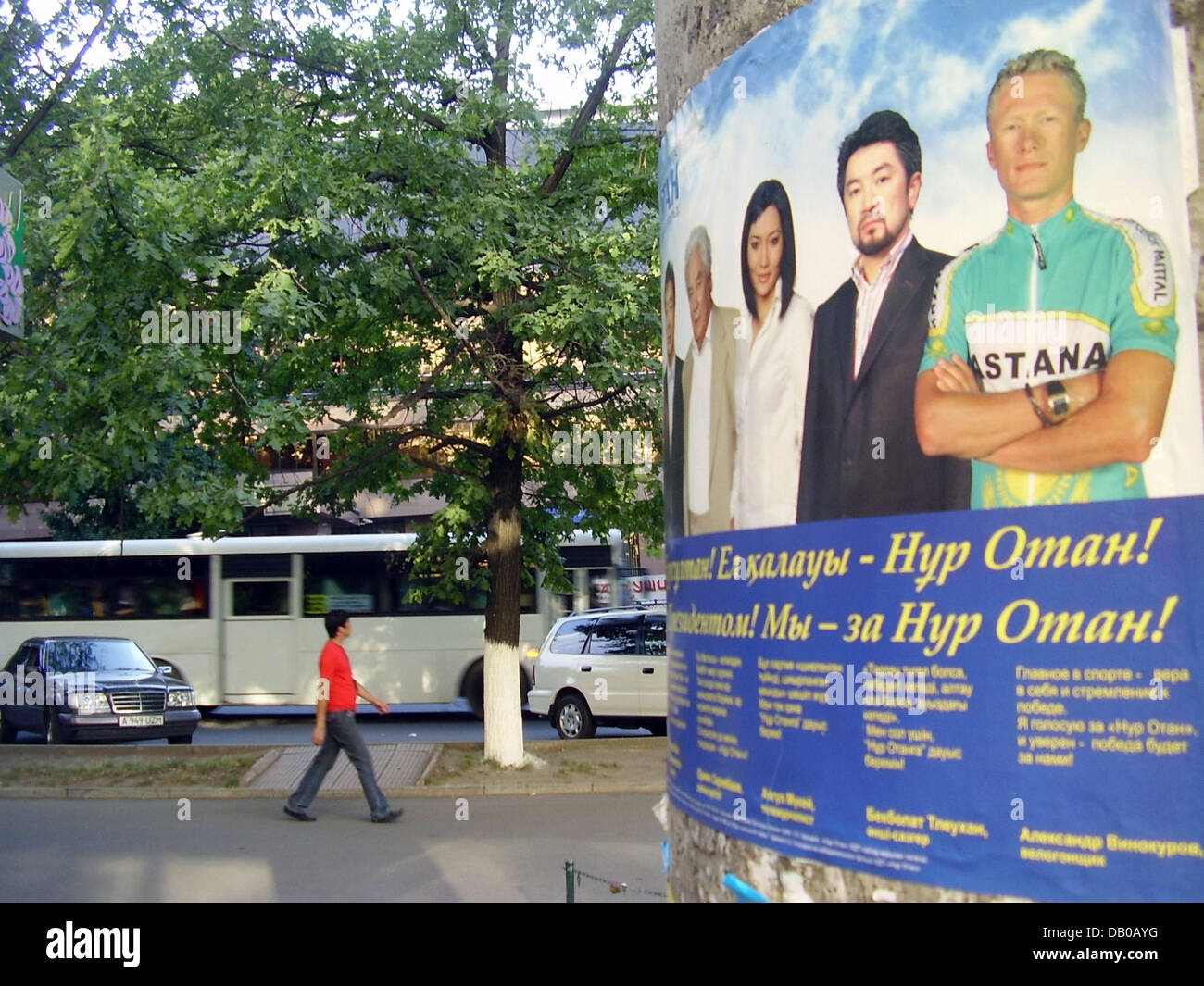 A man passes an election poster for the Kazakh party 'Nur Otan' (Shining Fatherland) in Almaty, Kazakhstan, 30 July 2007. Seven prominent Kazakhs are pictured on the poster, also cyclist Alexander Vinokourov (R). The doping scandals at this years 'Tour de France', also involving Vinokourov, have not caused harm to his popularity at his native Kazakhstan. The country holds parliamen Stock Photo