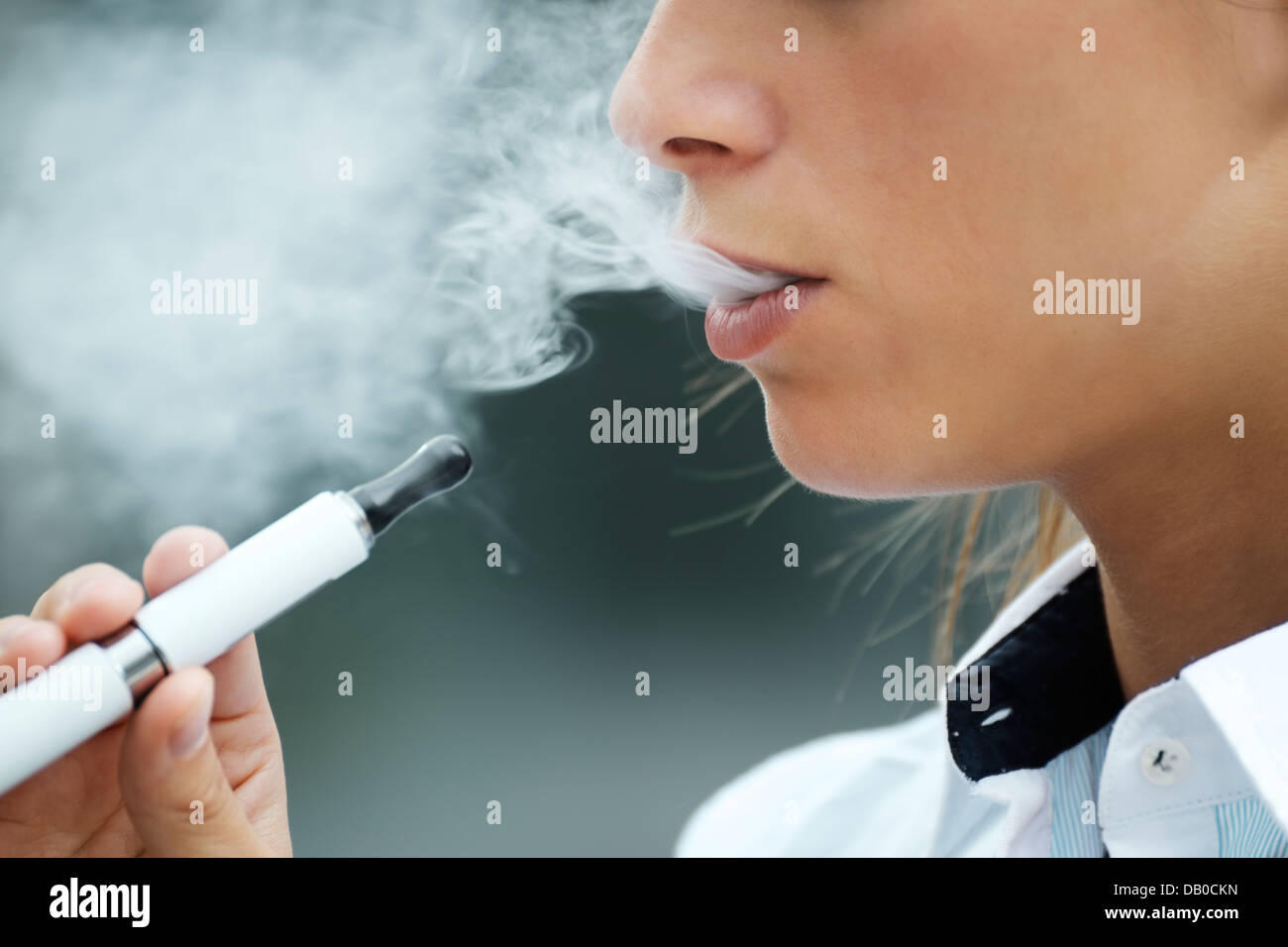 closeup of woman smoking e-cigarette and enjoying smoke. Copy space Stock Photo