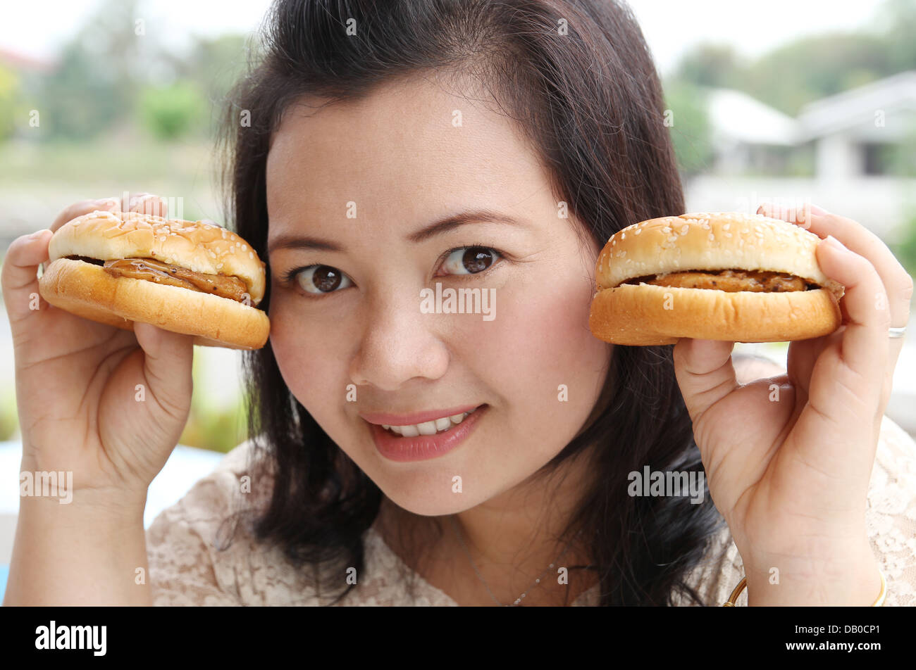 closeup image of asian woman eating hamburger at coffeeshop Stock Photo