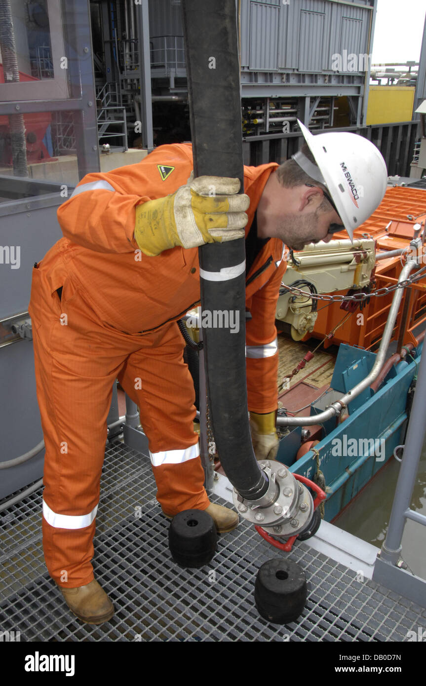 A Worker Handles A Hose Line On The Mittelplate Oil Rig At The