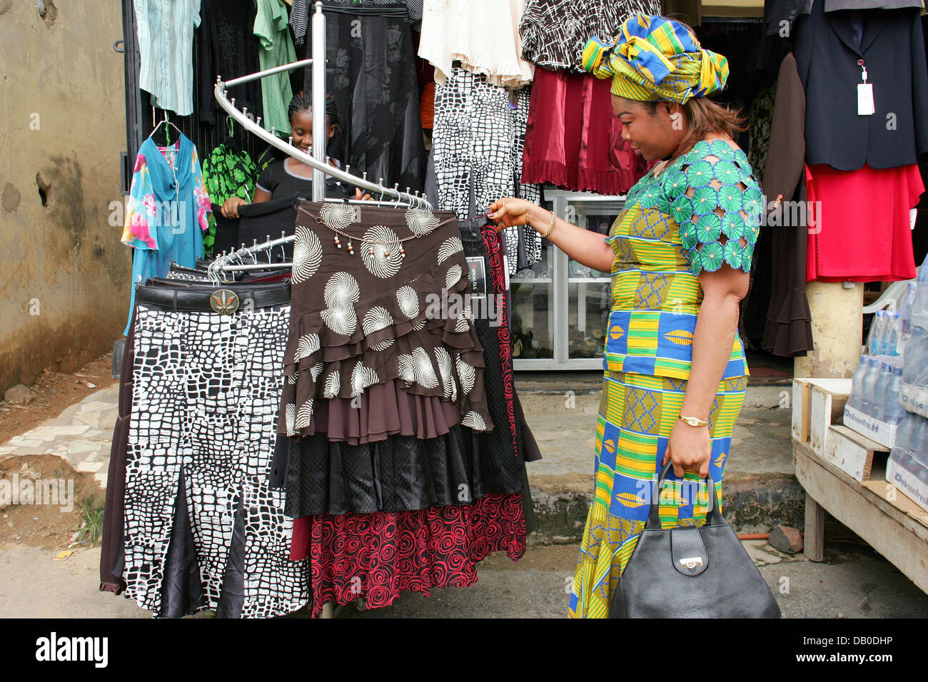 A woman looks for clothes on a clothes' rack at a market in Abuja ...