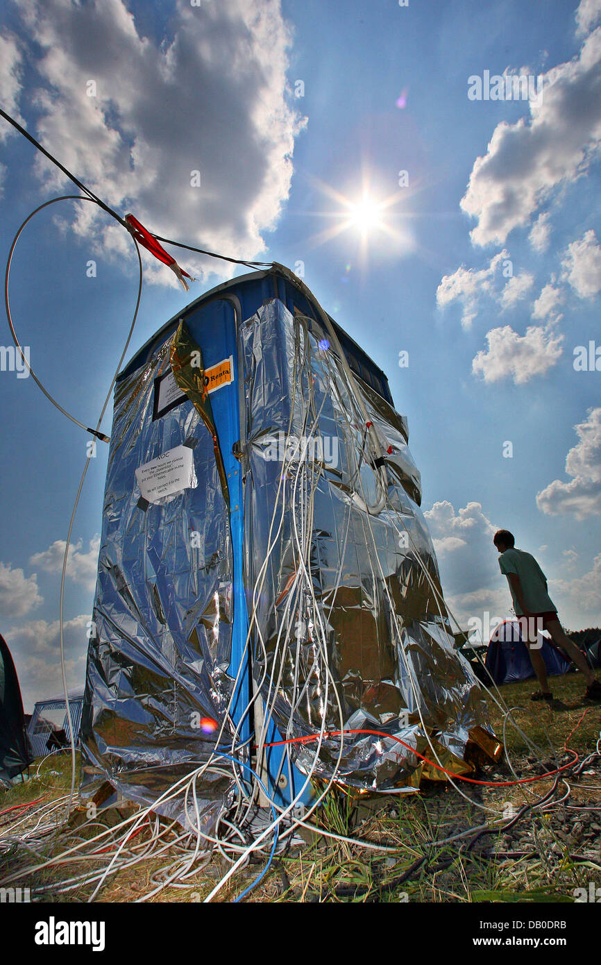A participant of the 'Chaos Communication Camp 2007' walks past a 'Data  Loo', a transformed toilet box containing network cable connections, on the  compounds of the Aviation Museum ('Luftfahrtmuseum') Finowfurt, Germany, 9
