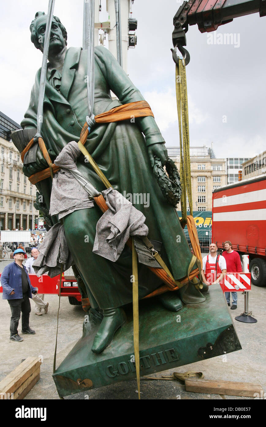A crane is used to lift a statue of Johann Wolfgang von Goethes into its place at the Goethe square in Frankfurt Main, Germany, 13 August 2007. After months long restaurations the statue of Frankfurt's most famous son was put back in its place. The statue will stay covered untill the poets 258th birthday on August 28th when the staue will be presented to the public. Photo: Boris Ro Stock Photo