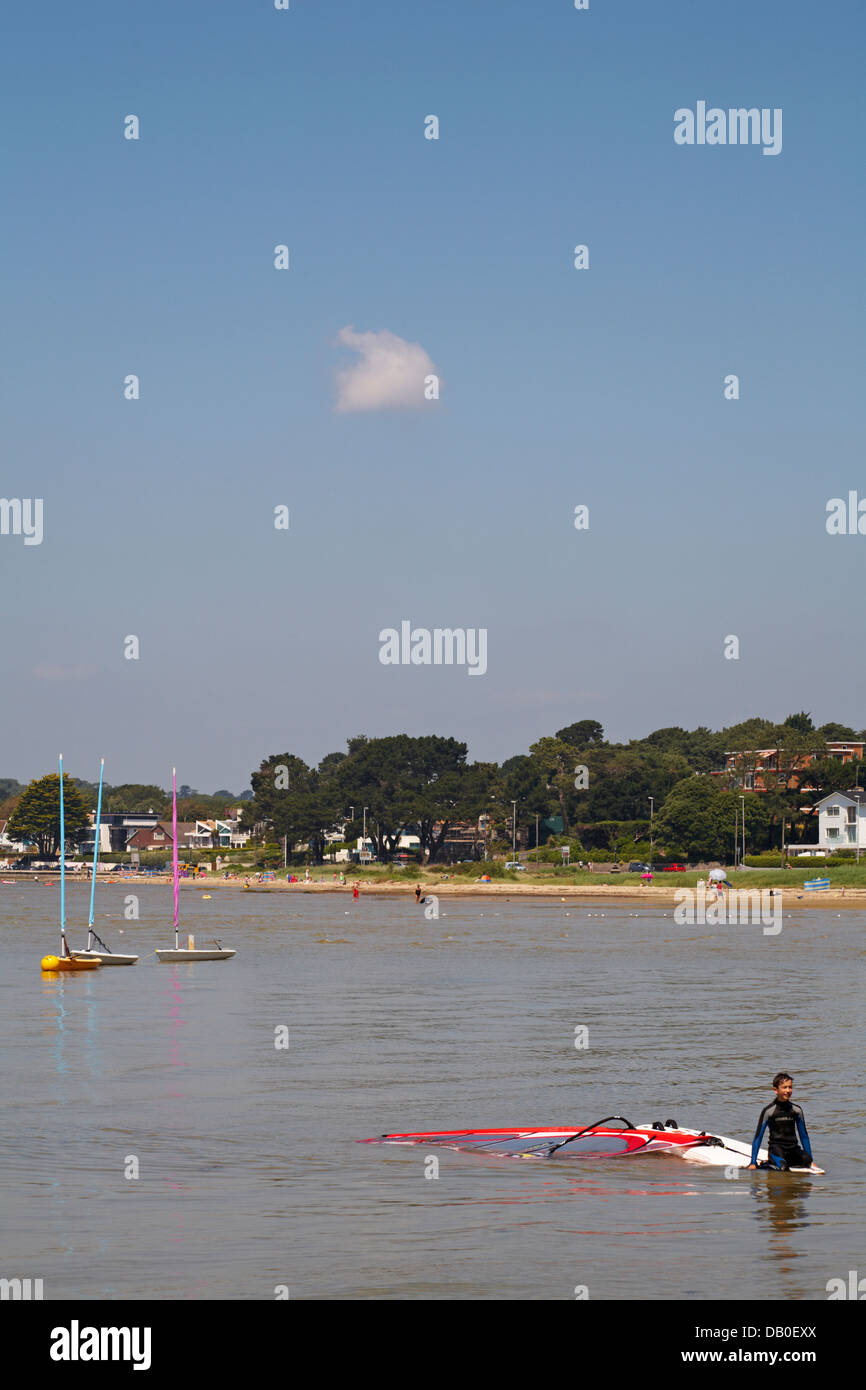 young boy pulling windsurfing sail and board with three Pico laser