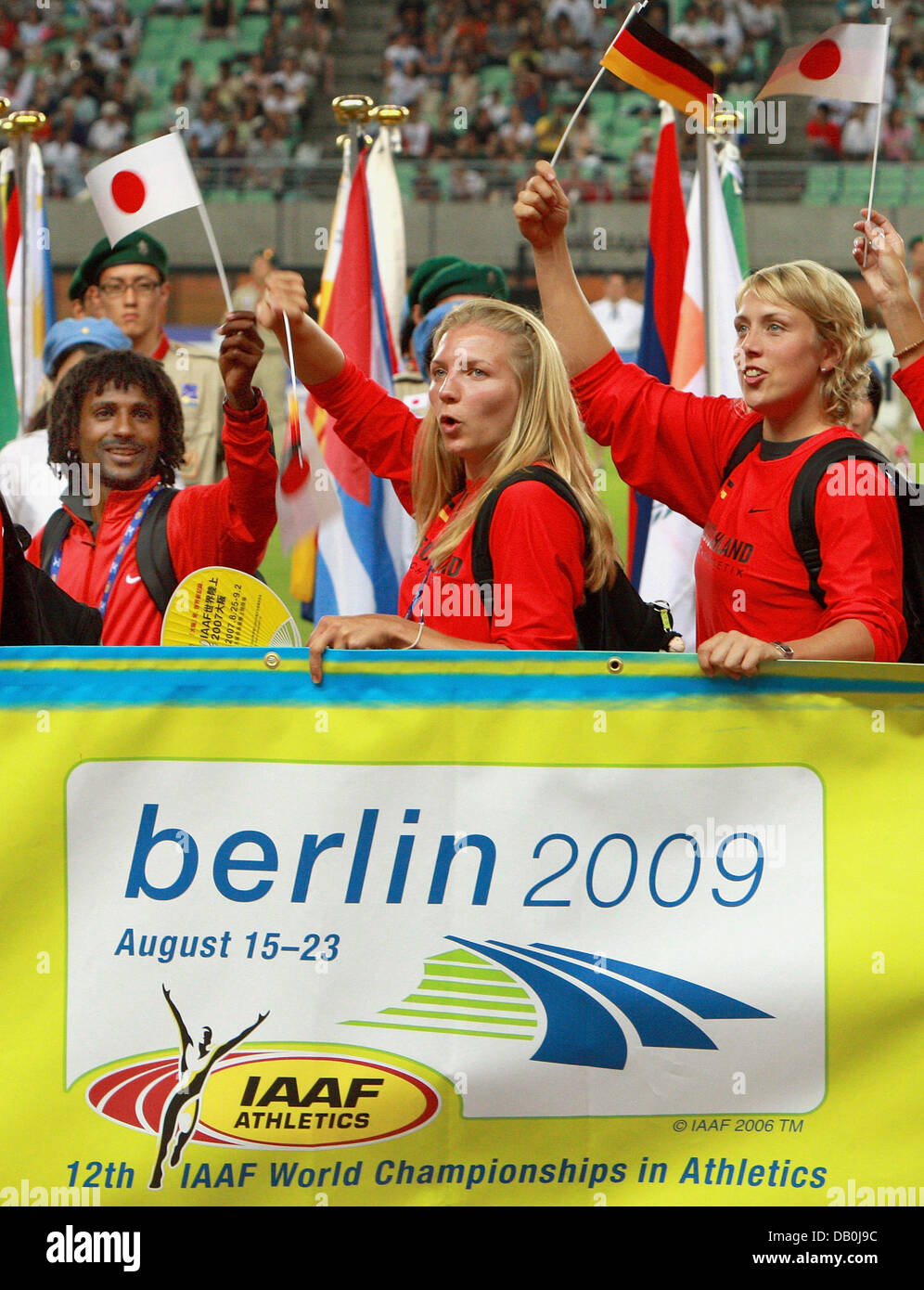 German athletes (L-R) Filmon Ghirmal, Lilli Schwarzkopf and Christina Obergfoell  pose with a banner displaying the logo of Berlin 2009 during the closing ceremony of the 11th IAAF World Championships in Athletics at Nagai stadium of Osaka, Japan, 02 September 2007. The IAAF flag was passed on to the city of Berlin hosting the 12th IAAF World Championships in Athletics in 2009. Pho Stock Photo
