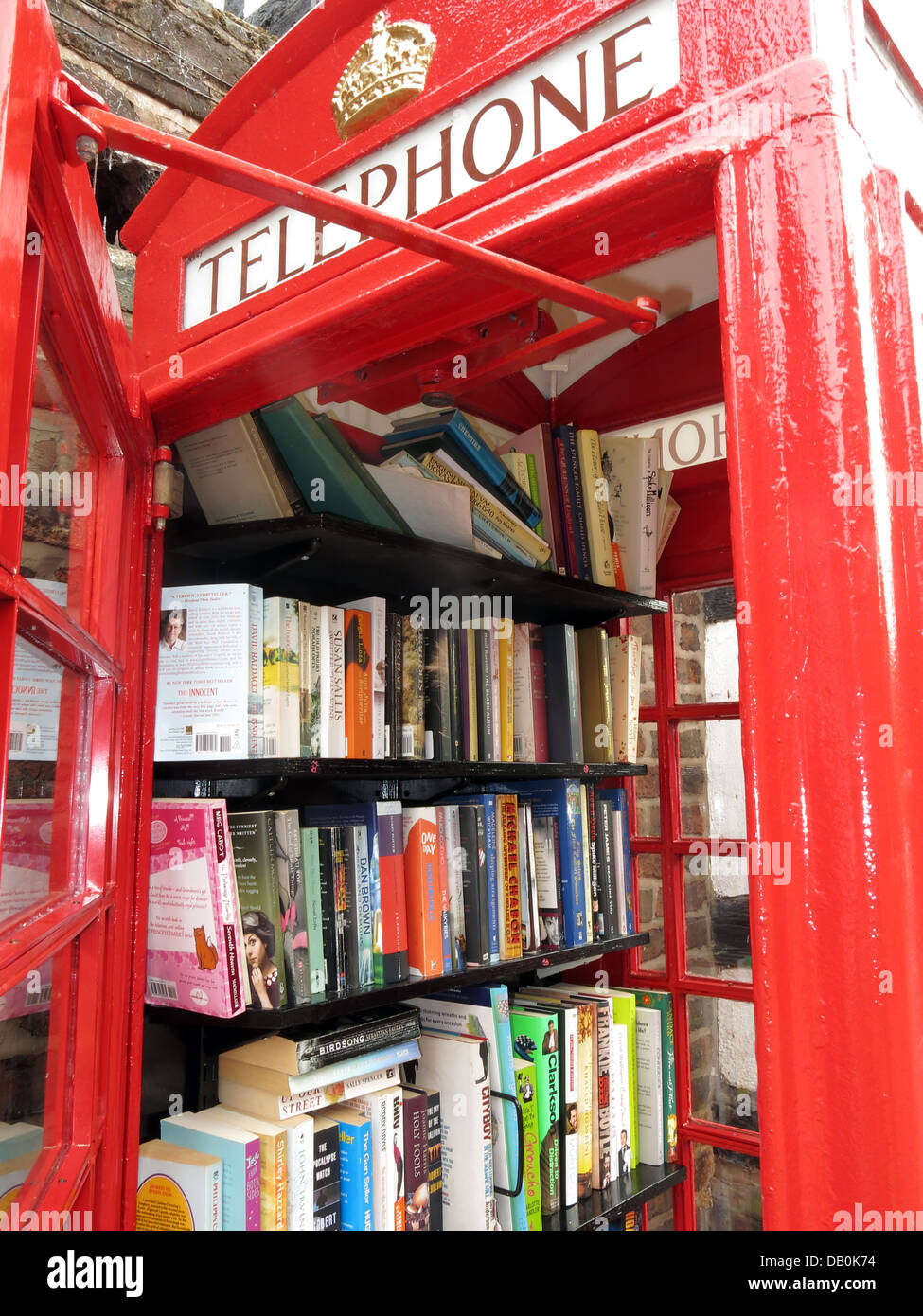 Interior of an old red British Telephone box turned into a British village eccentric lending library Stock Photo