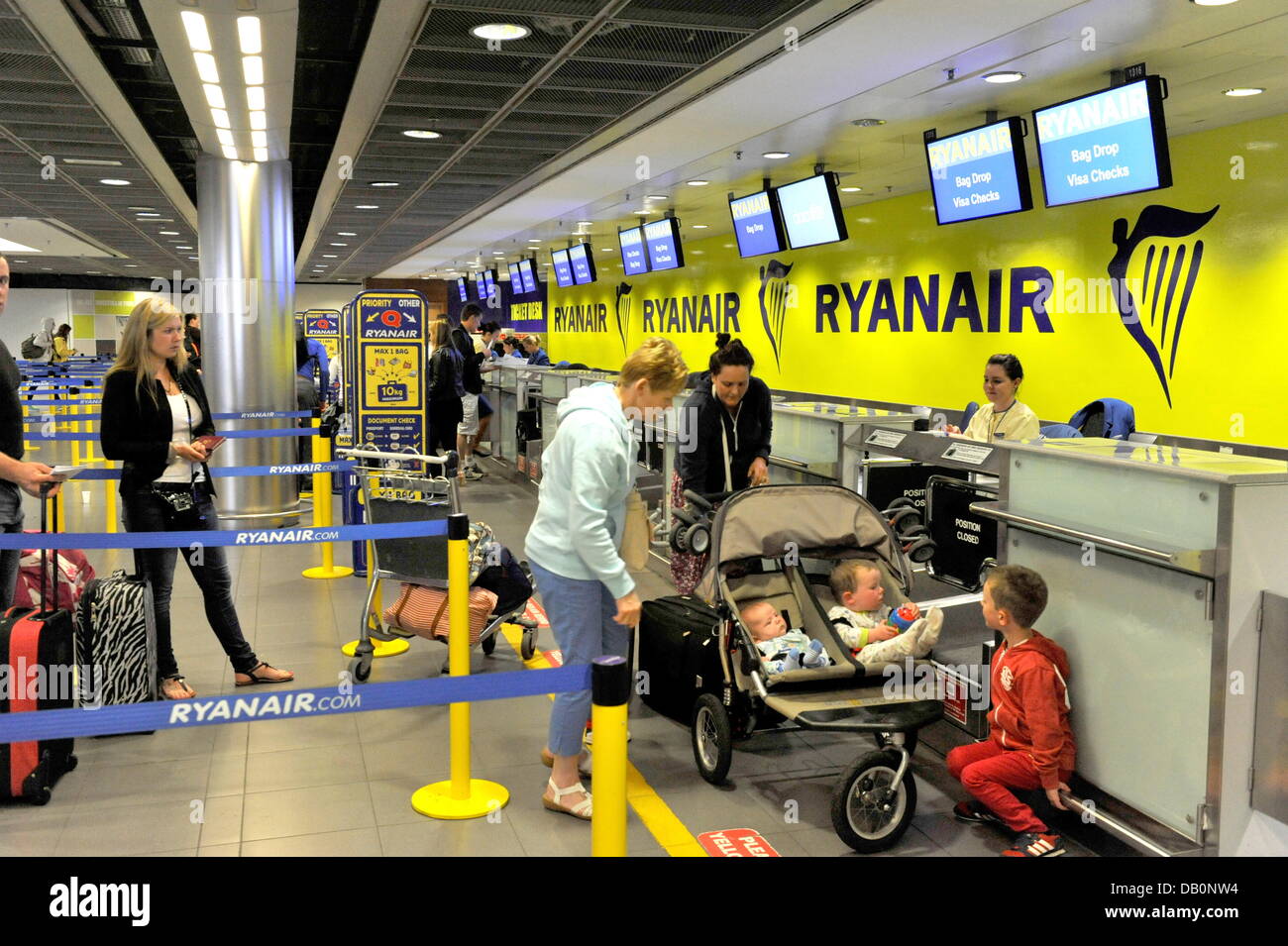 Passengers of the irish airline company Ryanair stand on June 28, 2013, in front of a check-in counter at Dublin Airport. Stock Photo