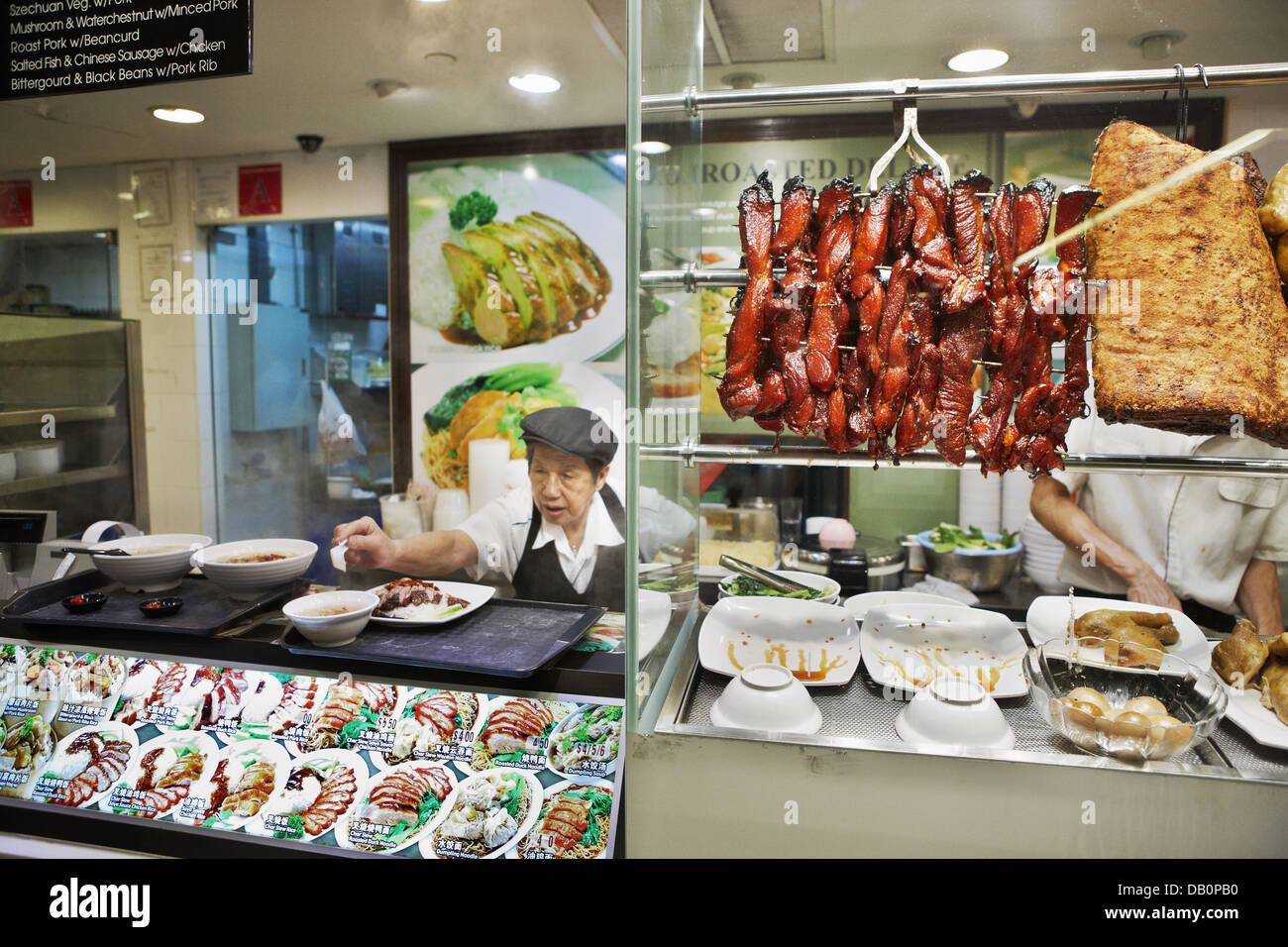 Food stall serving traditional Asian dishes in an indoor hawker center. Singapore. Stock Photo