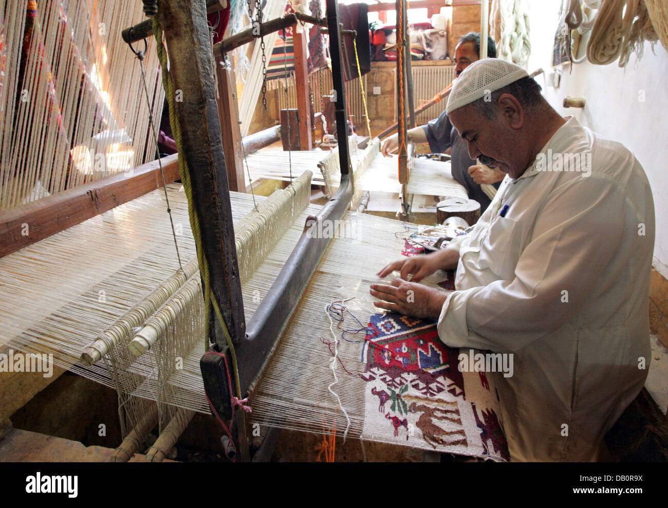 A rug maker works on his loom in the historic city centre of Aleppo, Syria, 30 August 2007
