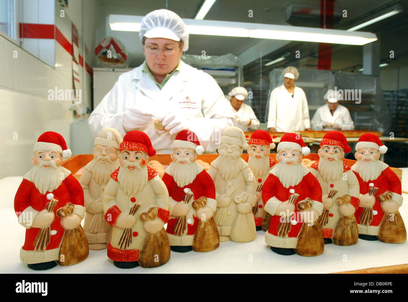 Marzipan santas smile getting painted by an employee of Niederegger in Luebeck, Germany, 14 September 2007. Founded 200 years ago by Johann Georg Niederegger produces up to 30 tons of marzipan per day, a privilege granted to pharmacists only until the 18th century. Nowadays, more than 700 employees do their job to achieve a turnover of 100 to 200 million euro per annum. Photo: Wolf Stock Photo