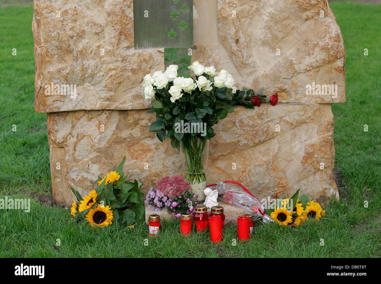 White roses, candles and sun flowers are laid to a memorial stone during a oecumenical service in Lathen, Germany, 22 September 2007. Exactly one year ago, a Transrapid train crashed on the test track, 23 people were killed. Photo: Firso Gentsch Stock Photo