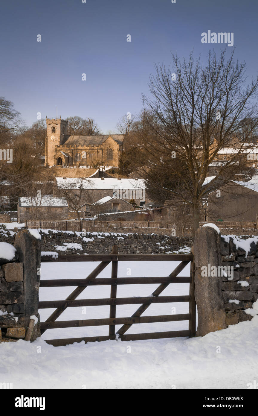 The beautiful village of Downham, Lancashire. Captured here covered in snow and the last rays of the sun illuminating the church Stock Photo
