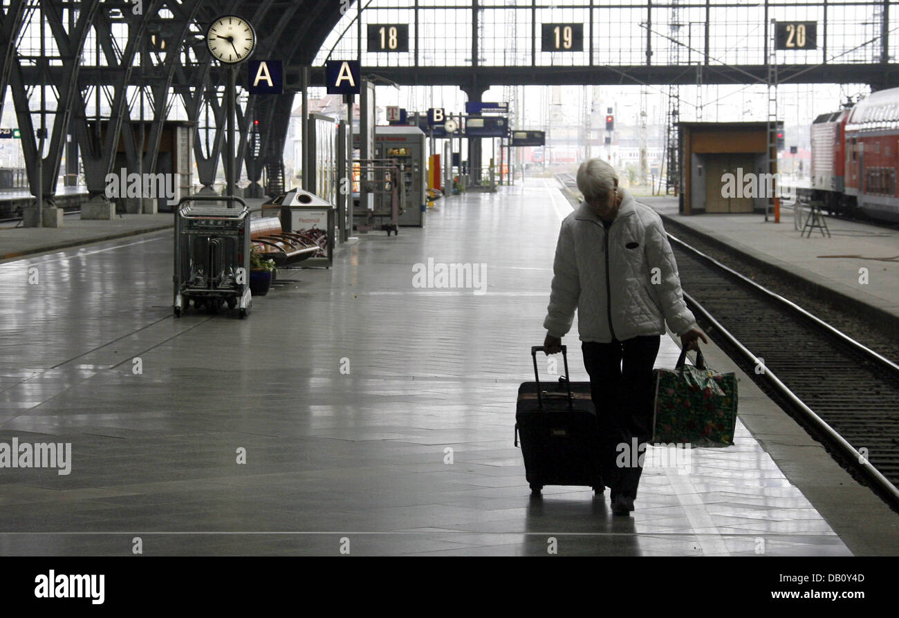 A railways customer walks along a deserted track at the main train station in Leipzig, Germany, 05 October 2007. The short-distance traffic of the German railways company 'Deutsche Bahn' (DB) is strike-hit in Saxony, Saxony-Anhalt and Thuringia since eight o'clock this morning. Members of the German trade-union present in train companies (GDL)carried out their threat and went on st Stock Photo
