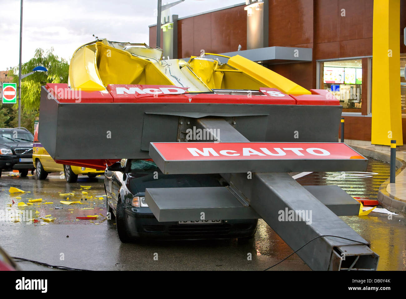 A collapsed McDonald's advertising panel crushes a vehicle in