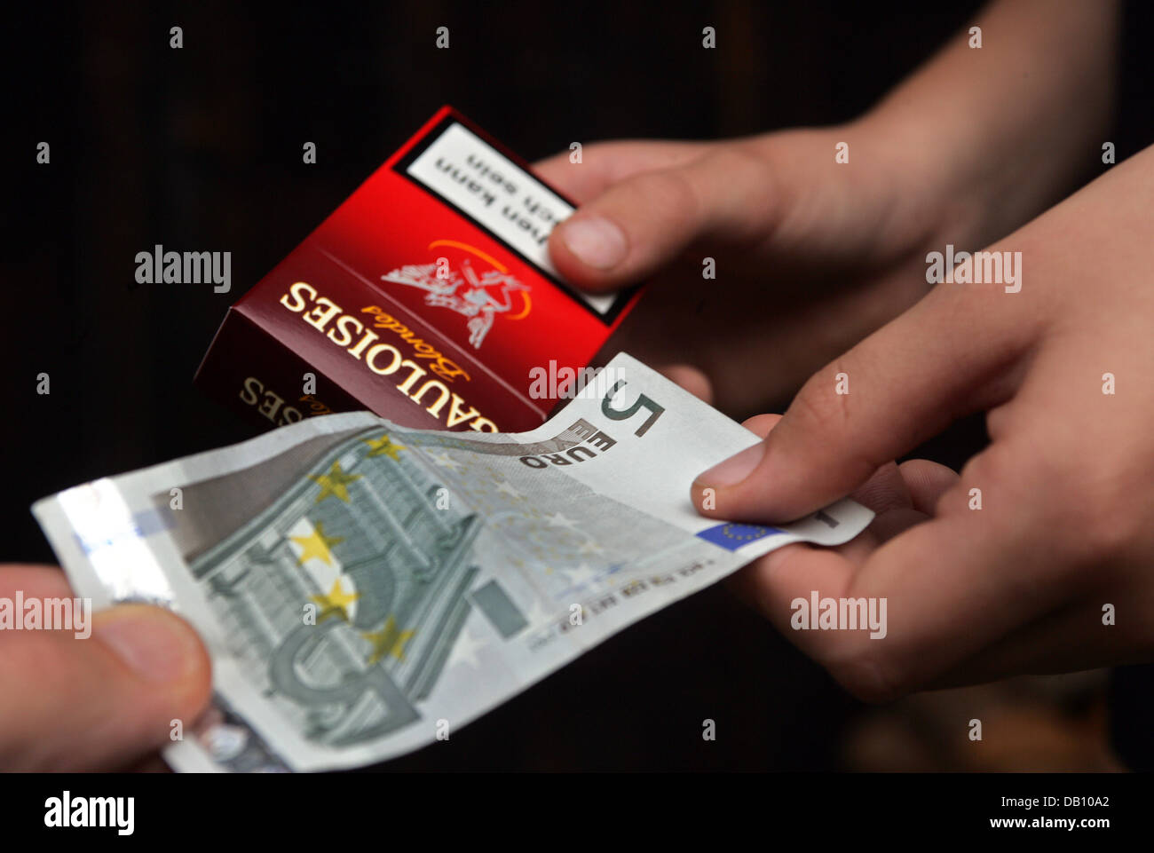 The staged photo shows a young man buying a pack of cigarettes in Kaufbeuren, Germany, 14 October 2007. The German government plans to tighten youth protection laws. In the course of this process youths between 14 and 18 years shall be employed as mystery shoppers to convict shop owners illegally selling liquor, tobacco, violent movies and so-called 'killer' computer games to under Stock Photo