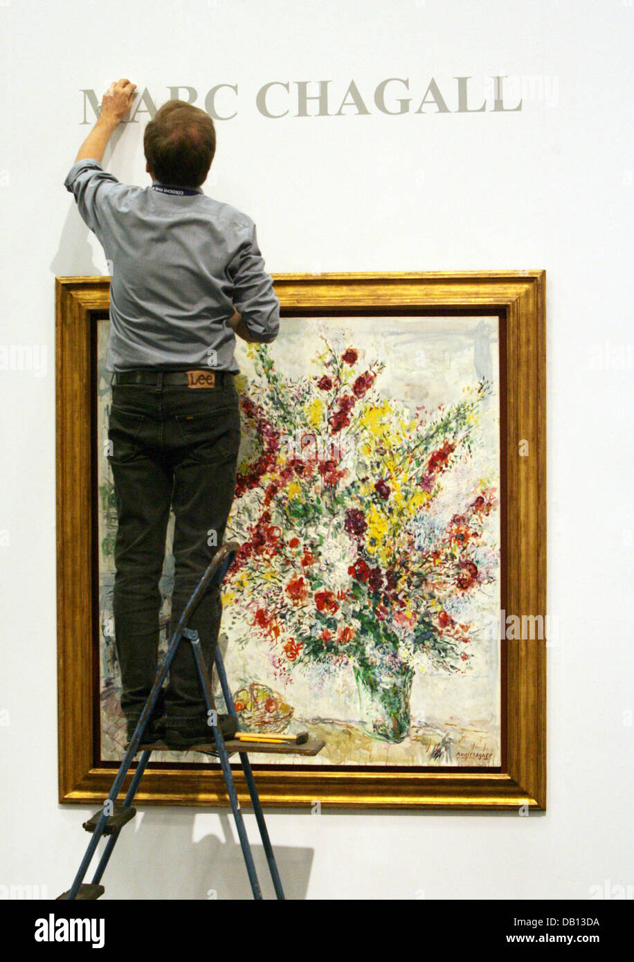 A man puts up the name of painter Marc Chagall above his work 'Bouquet de fleurs et prunes' (1969) at the stand of Frankfurt-based Gallery 'Die Galerie' at the Cologne Fine Arts Trade Fair in Cologne, Germany, 30 October 2007. Some 160 gallery owners, art dealers, and antique dealers will exhibit objects at the art trade fair taking place from 31 October to 04 November 2007 in Colo Stock Photo