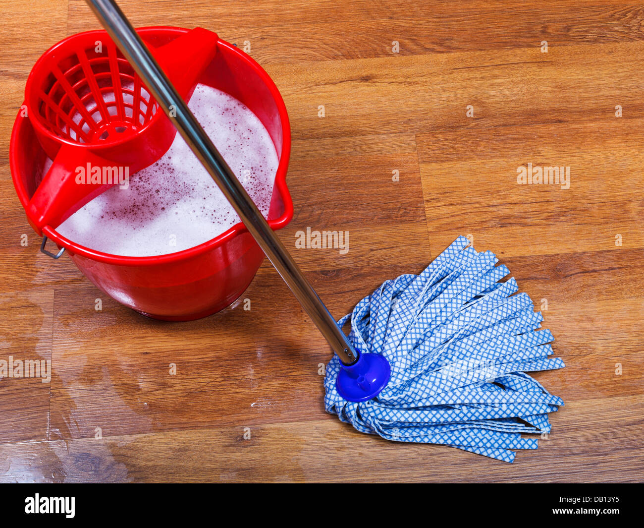 blue mop and red bucket on wet floor Stock Photo