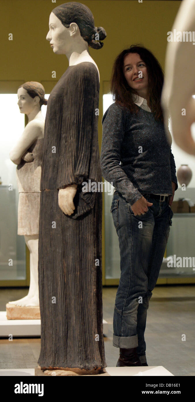 A woman stands next to a terra cotta sculpture dubbed 'Mona' by Berlin based artist Robert Metzkes at the recently redesigned and restored Museum of Applied Arts inside the Grassi-Museum building in Leipzig, Germany, 2 November 2007. Within five years the museum invested more than one million euros in the restoration of its applied art gems. A first exhibition named 'Von der Antike Stock Photo