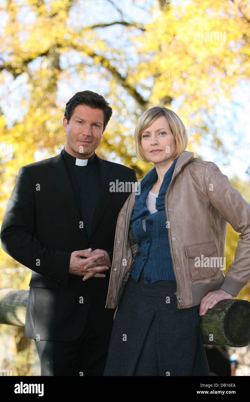 German actress Christine Doering and British actor Francis Fulton-Smith stand next to each other for photographers at the sidelines of the shooting for German TV station ZDF's upcoming detective story 'Das fuenfte Gebot' (literally: 'The Fifth Commandment') in Strasslach near Munich, Germany, 5 November 2007. Fulton-Smith stars as padre Simon Castell while Doering acts as Marie Bla Stock Photo