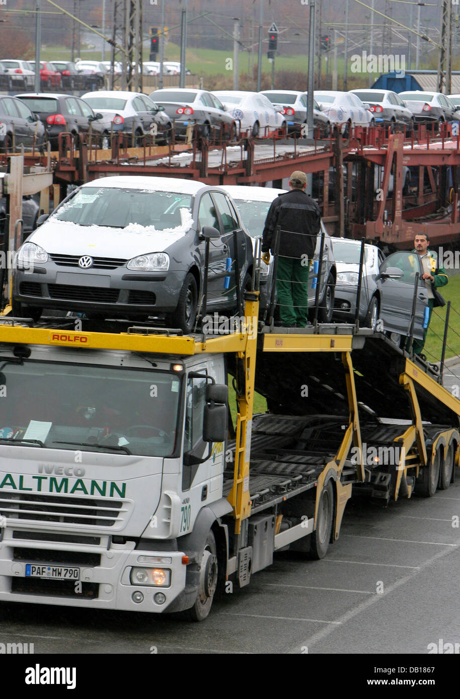 A car transporter is loaded with Volkswagen cars that normally would have been shipped by train in Zwickau Mosel, Germany, 16 November 2007. In the background is a train loaded with Volkswagen cars. Because of the engine driver's strike the company has problems transporting cars. The factory in Zwickau makes 1212 VW Golf and Passat cars and 70 auto bodies for Volkswagen model Phaet Stock Photo