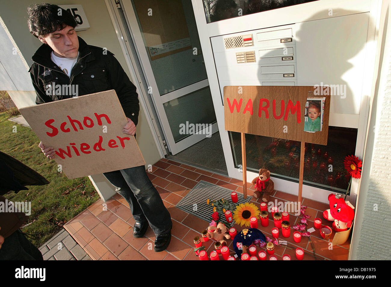 Mourning Timo Tasche from Marl holds a sign which reads 'Schon wieder'  (again) at the home of five-year-old malnourished Lea-Sophie, who was taken  to hospital Tuesday (20 November) night and died shortly