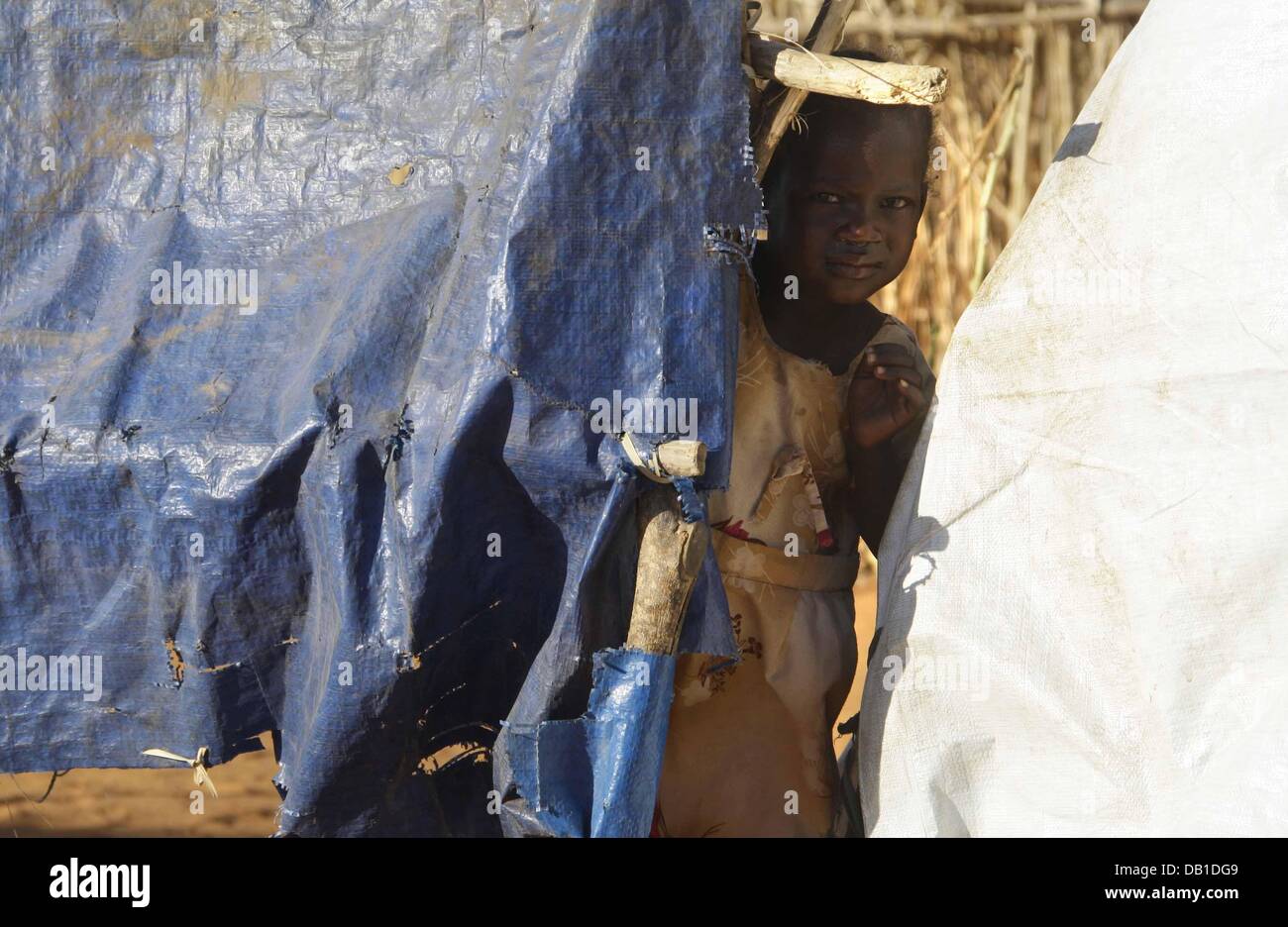 A small refugee girl hides in a refugee camp in Nyala in the Darfur region, Sudan, 12 December 2007. 35.000 refugees live in the camp. Photo: PETER STEFFEN Stock Photo