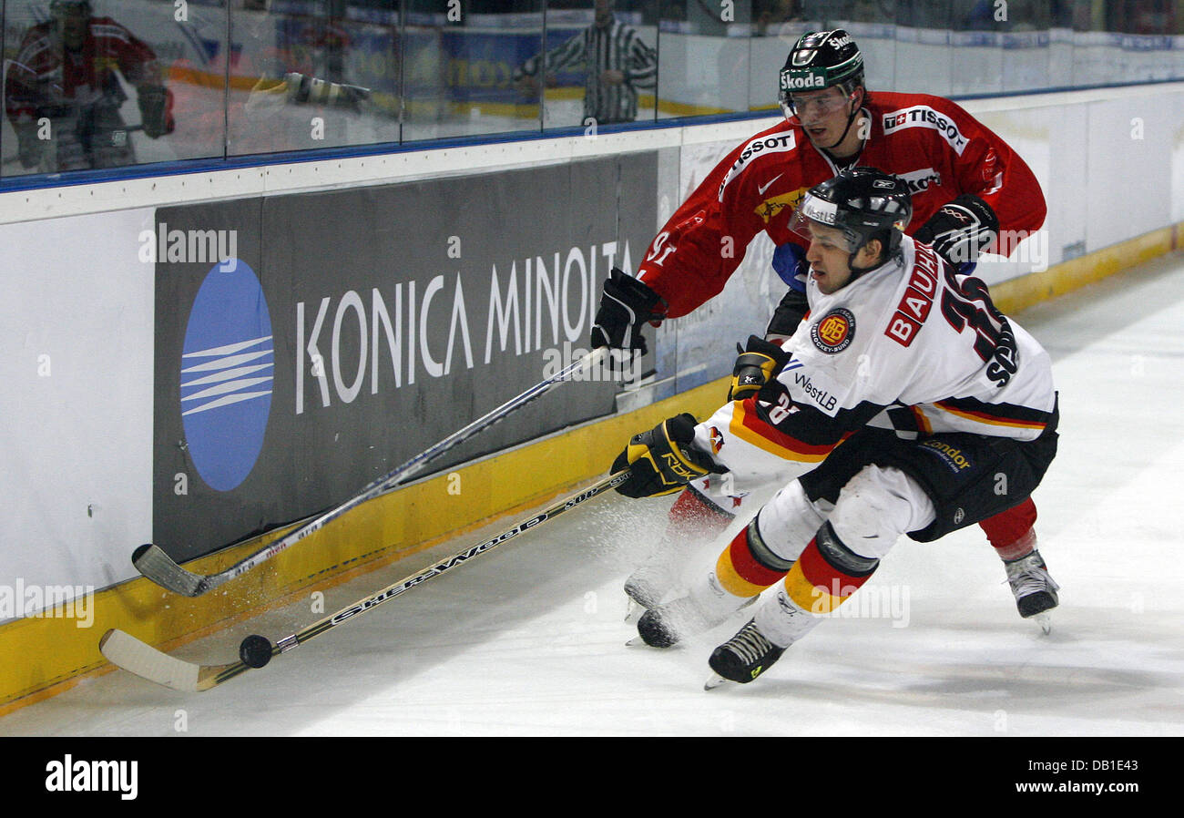 German Chris Schmidt (front) faces Swiss Mathias Joggi during the international ice hockey match at the arena in Nuremberg, Germany, 12 December 2007. Photo: Daniel Karmann Stock Photo