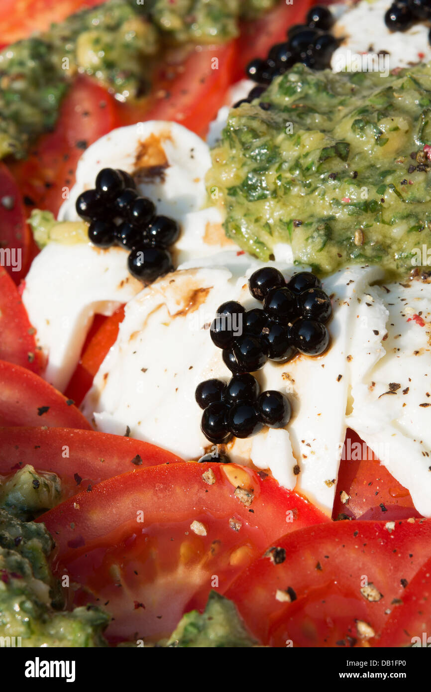 An Italianstyle salad of tomatoes, buffalo Mozzarella, fresh pesto