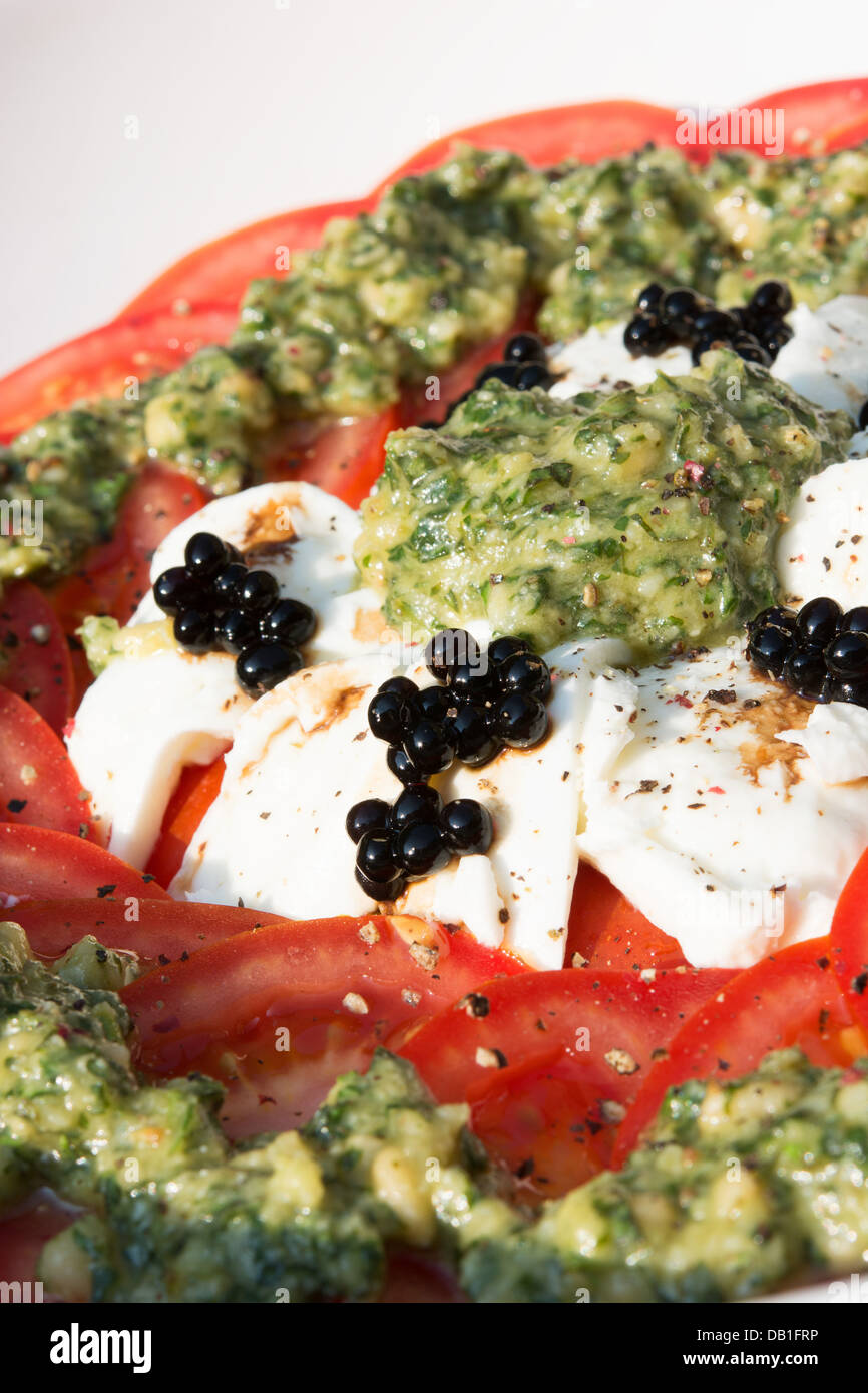 An Italianstyle salad of tomatoes, buffalo Mozzarella, fresh pesto