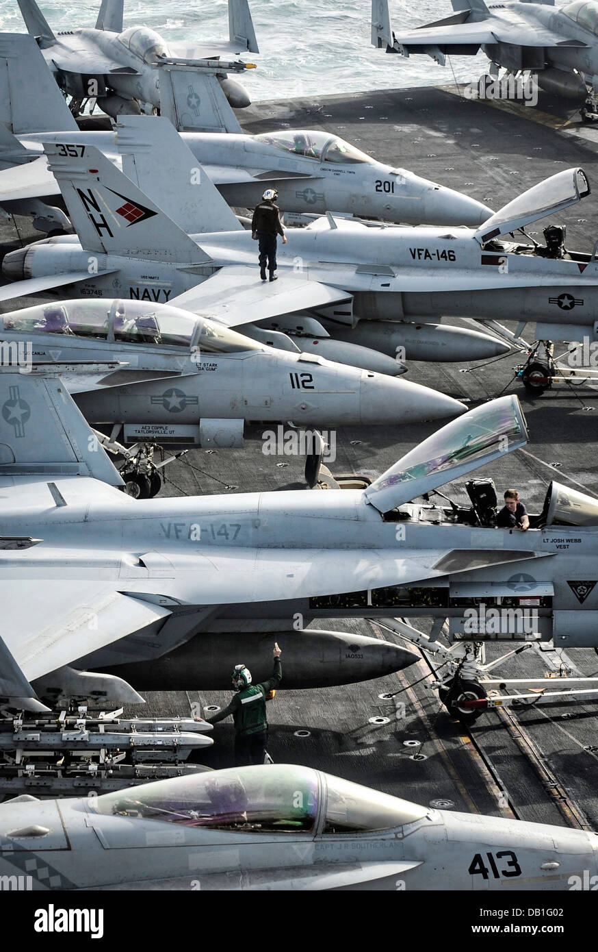 US sailors prepare aircraft for operations on the flight deck of the aircraft carrier USS Nimitz July 20, 2013 in the North Arabian Sea. Nimitz Strike Group is deployed to the U.S. 5th Fleet area of responsibility conducting maritime security operations, theater security cooperation efforts and support missions for Operation Enduring Freedom. Stock Photo