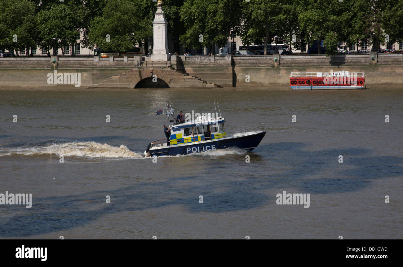 A police launch on the River Thames in the shadow of the London Eye. Stock Photo