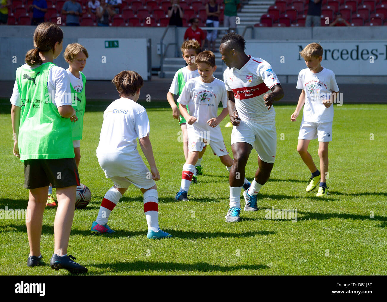 Stuttgart, Germany. 21st July, 2013. Stuttgart's Arthur Boka (2-R) practices with young soccer players at the beginning of the new Bundesliga soccer season 2013/14 at Mercedes-Benz-Arena in Stuttgart, Germany, 21 July 2013. Photo: Daniel Maurer/dpa/Alamy Live News Stock Photo