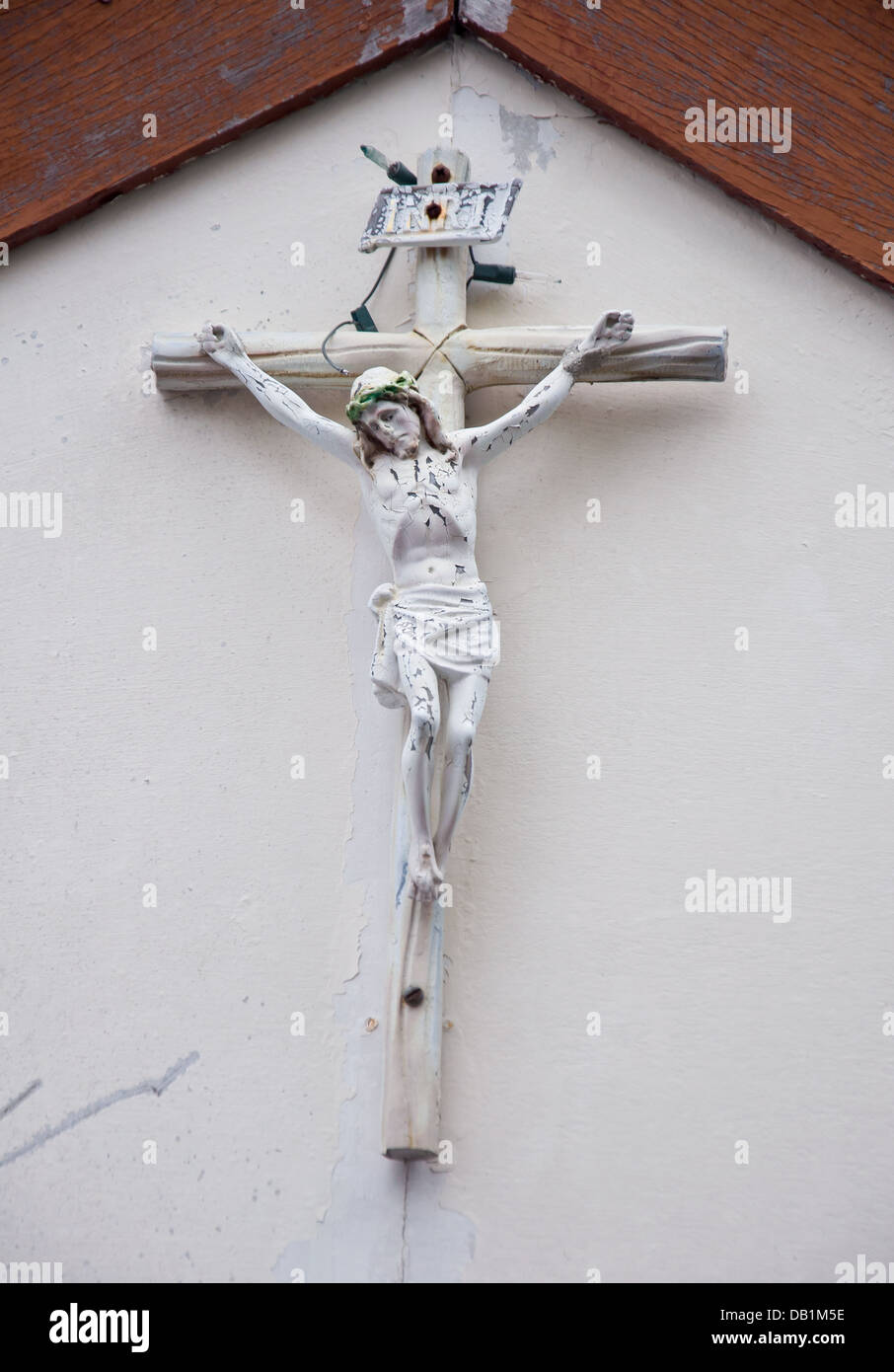 old Jesus statue on wall of christian church Stock Photo