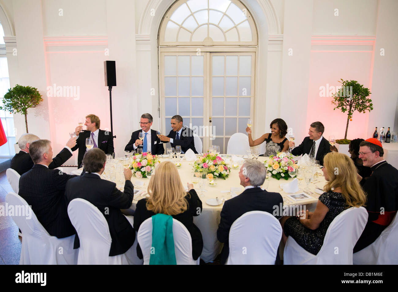 US President Barack Obama and First Lady Michelle Obama raise their glasses in a toast with other guests during a dinner hosted by German Chancellor Angela Merkel at Schloss Charlottenburg June 19, 2013 in Berlin, Germany. Stock Photo
