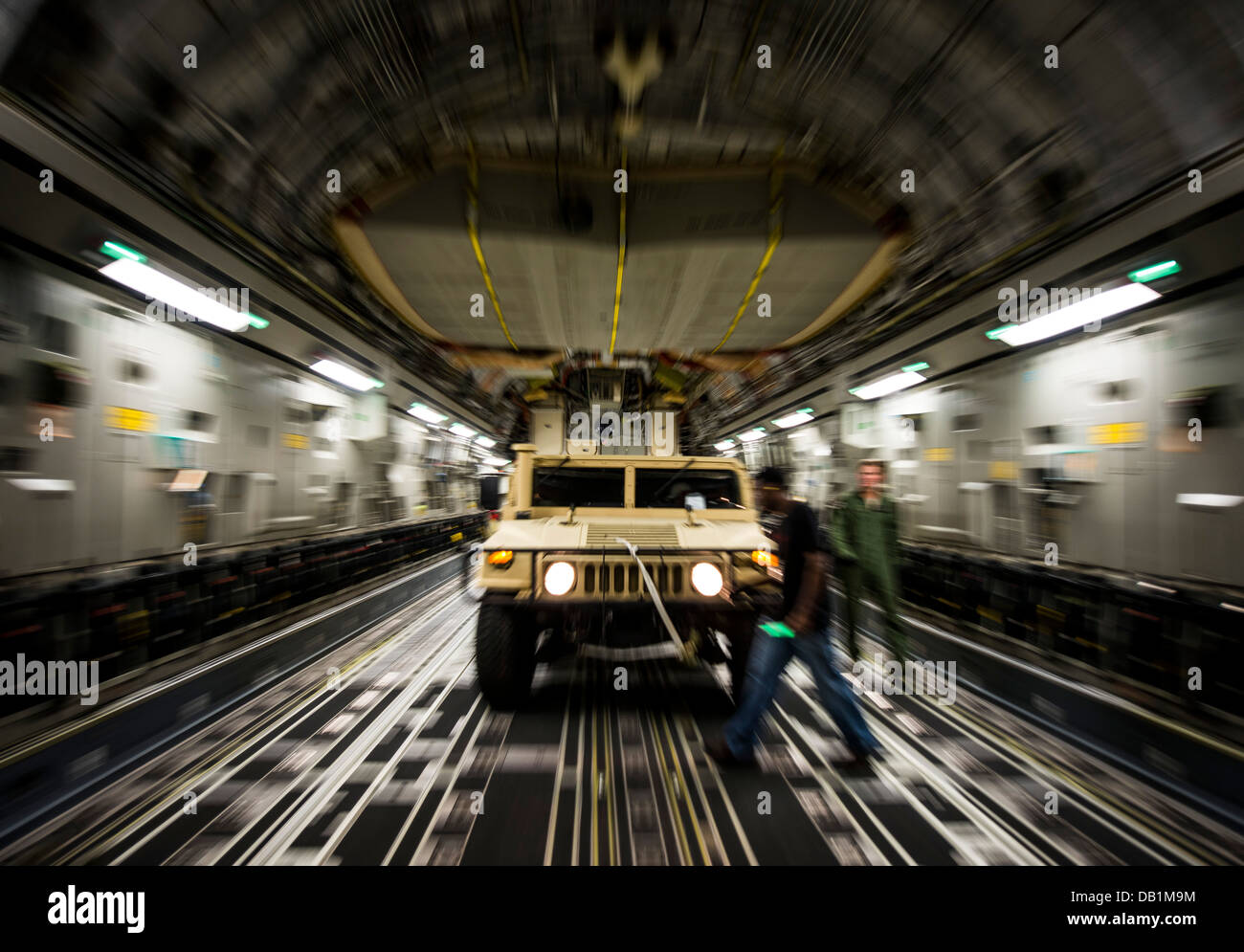A Humvee is loaded onto a C-17 Globemaster III during an exercise to practice combat on-loading and off-loading July 17, 2013, at Joint Base Charleston - Air Base, S.C. Airmen from the 437th Airlift Wing work around the clock on the flight line to provide Stock Photo