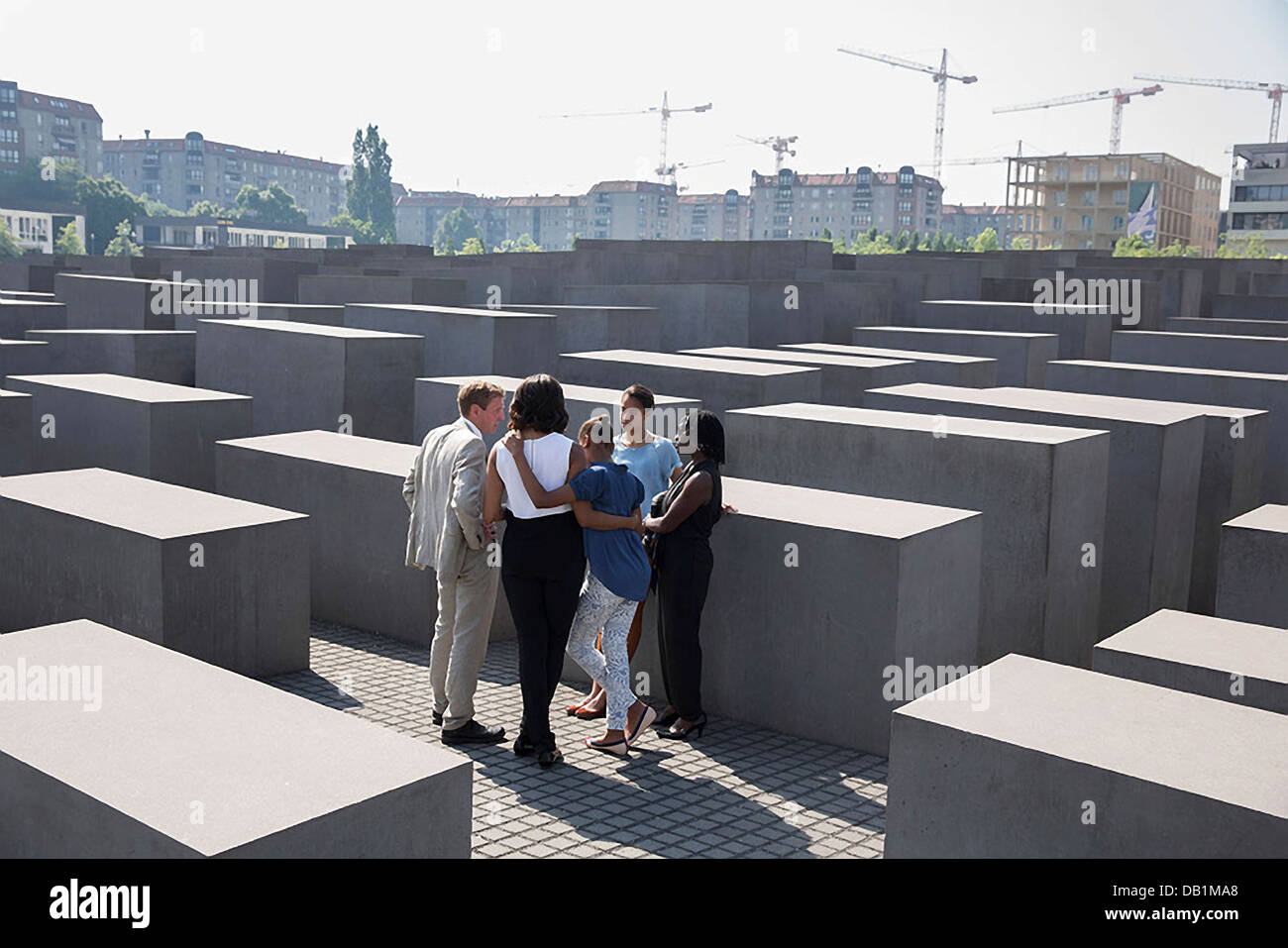 US First Lady Michelle Obama, along with daughters Sasha and Malia, listens to Foundation Director Uwe Neumarker during their visit to the Memorial to the Murdered Jews of Europe June 19, 2013 in Berlin, Germany. Sister-in-law Auma Obama, right, accompanies them during the tour. Stock Photo