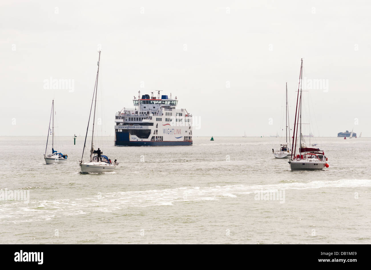 An Isle of Wight ferry and sailing boats pass in Portsmouth Harbour, UK. Stock Photo