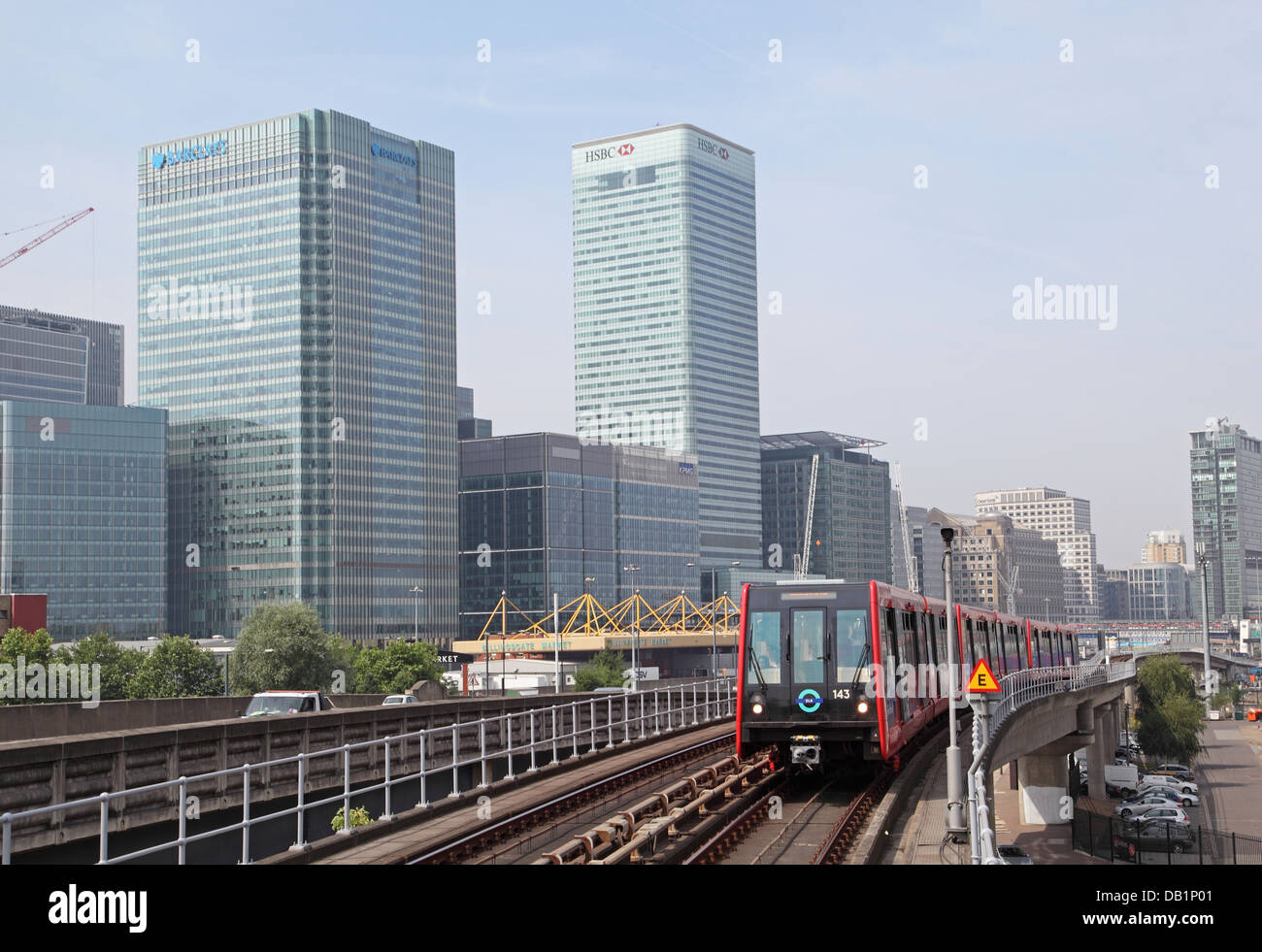 A London Docklands Light Railway train approaches Blackwall station. Canary Wharf business district in the background Stock Photo